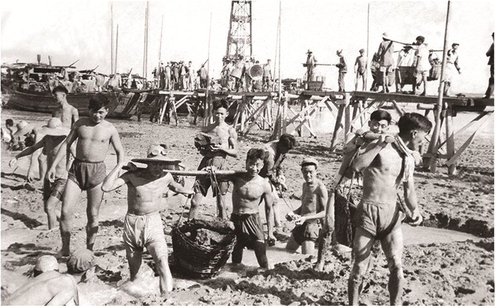 1958年南钢建设初期，创业者们肩抬手搬从江边运送铁矿石.jpg